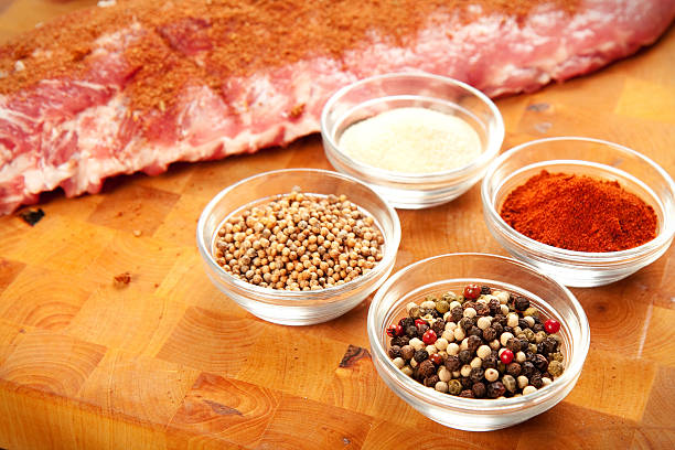 A rub of various spices being prepared for barbecuing meat Babyback rib presented with common spices used for rub seasoning. Rub seasoning on rib. rubbing stock pictures, royalty-free photos & images