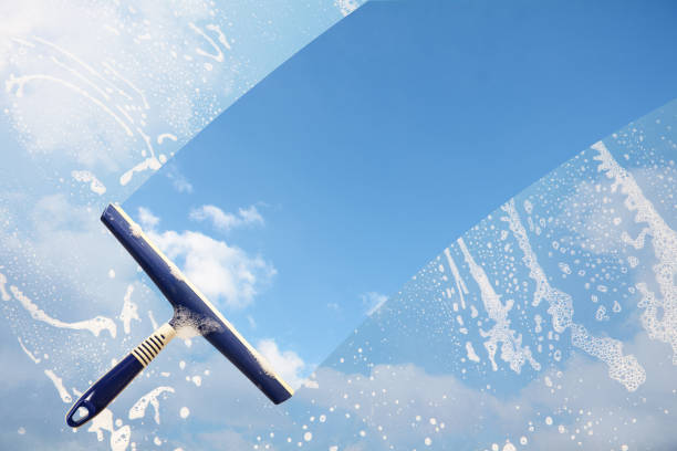ゴム製スキージ soaped ウィンドウをきれいにし、青い空の雲、スピンコートや大掃除、バック グラウンドでコピー スペースの概念のストライプをクリアします - 透明 ストックフォトと画像