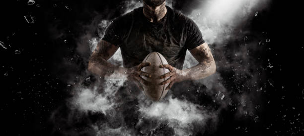Rugby player in action on dark stock photo