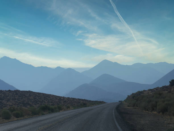 Rugged road with distant mountains in the background in Kern County, California. stock photo