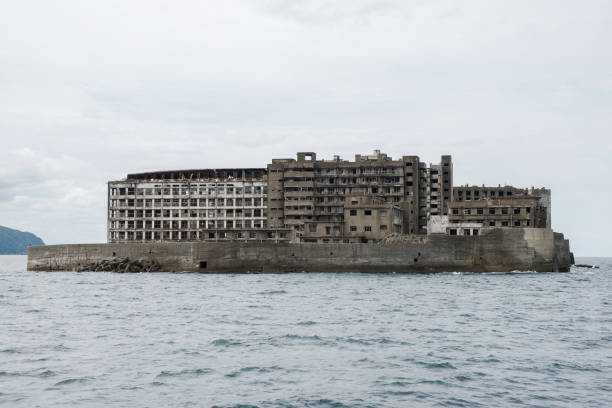 Ruins in Hashima Island, Japan Hashima Island, Japan - 11 April 2019: Hashima Island-Gunkanjima meaning Battleship Island, is an abandoned island lying about 15 kilometers (9 miles) from the city of Nagasaki, in southern Japan. This is former coal mining island. It is old coal mine in Japan closed at 1974 due to the closure of coal mine. sites of japan's meiji industrial revolution stock pictures, royalty-free photos & images