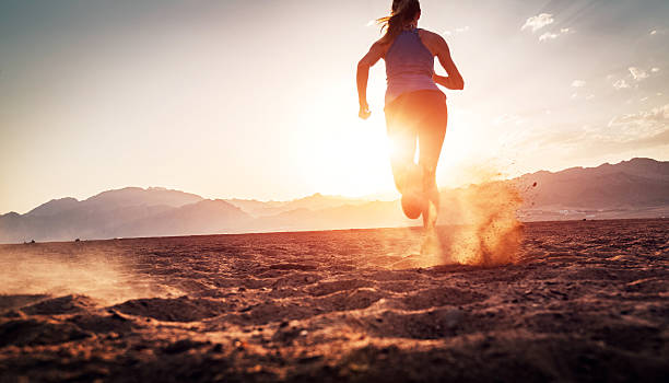 Runner Young lady running on the desert at sunset toughness stock pictures, royalty-free photos & images