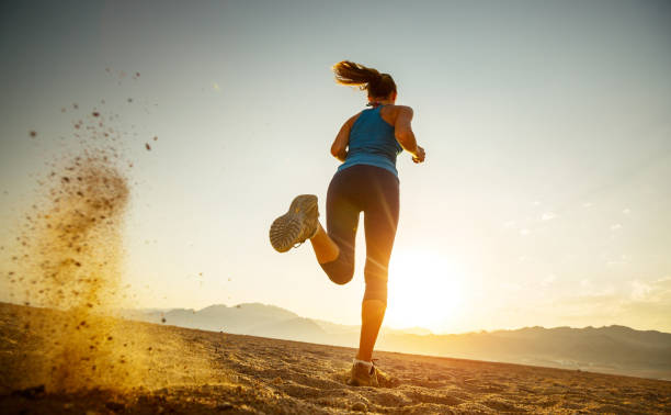 Runner Young lady running in the desert at sunset cross country running stock pictures, royalty-free photos & images