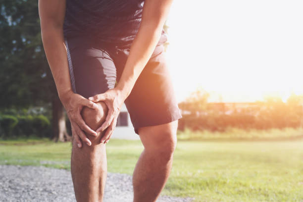 runner sport with running knee injury at park runner sport with running knee injury at park knee stock pictures, royalty-free photos & images