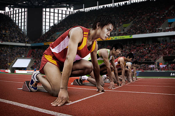 Runners at starting line in stadium  athleticism stock pictures, royalty-free photos & images