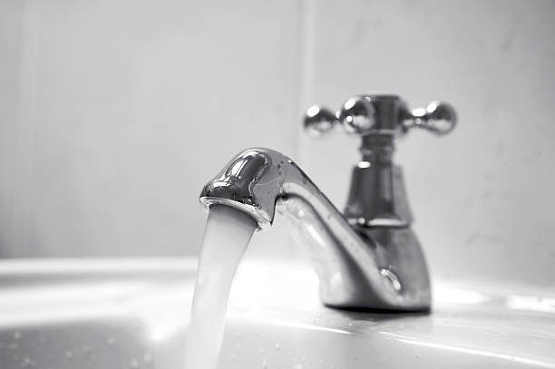 Running water Close up of chrome tap, water running. faucet stock pictures, royalty-free photos & images