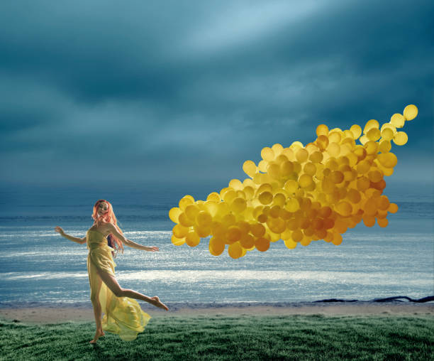 running jonge vrouwen met grote tak van gele ballonnen - rain woman sun stockfoto's en -beelden