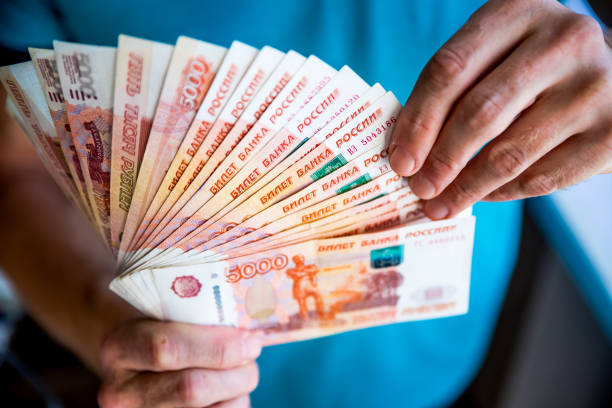 러시아 루블은 fan.male의 손에서 많은 러시아 지폐를 들고 손을. 돈의 양도입니다. 손에서 러시아 루블 명칭의 고립 된 5/1 - 러시아 루블 뉴스 사진 이미지