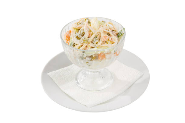 Russian salad with ham on plate white isolated stock photo