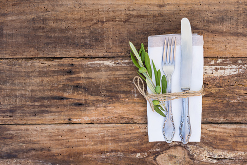 Table place setting with old silverware and wooden table.