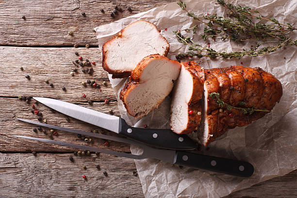 rustic food: roasted turkey breast  on table. horizontal top view - gebraden vlees stockfoto's en -beelden