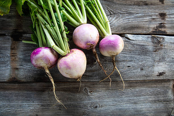 rustic organic turnips on genuine wood background for vegetarian food rustic organic turnips with fresh green tops and roots on genuine wood background for sustainable agriculture and vegetarian food, flat lay crucifers stock pictures, royalty-free photos & images