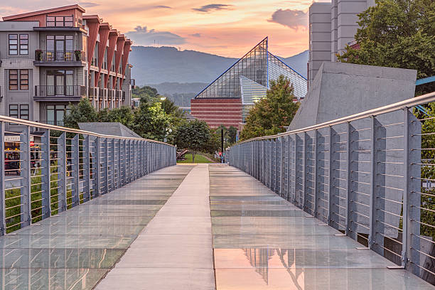 Ruth Holmberg Pedestrian Bridge at Sunset (HDR) The Ruth S. and A. William Holmberg Pedestrian Bridge in Chattanooga has a backlit glass floor and is popular with residents and tourists. Focus stacked HDR. Tennessee aquarium in background. chattanooga stock pictures, royalty-free photos & images