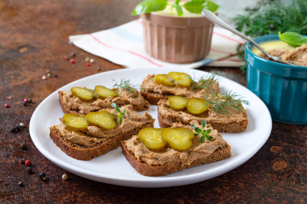 Rye bread with turkey liver pate and pickled cucumbers. Delicious appetizer. Rye bread with turkey liver pate and pickled cucumbers. Delicious appetizer. liver pâté photos stock pictures, royalty-free photos & images