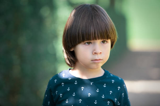 Sad child face portrait on blurry background stock photo