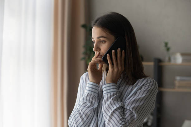 Sad compassionate young lady support friend in phone talk stock photo