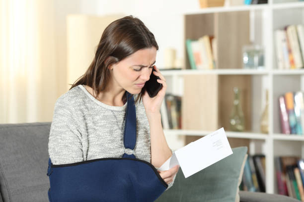 Sad disabled woman claiming on phone about notice Sad disabled woman claiming on mobile phone about paper notice at home assertiveness stock pictures, royalty-free photos & images