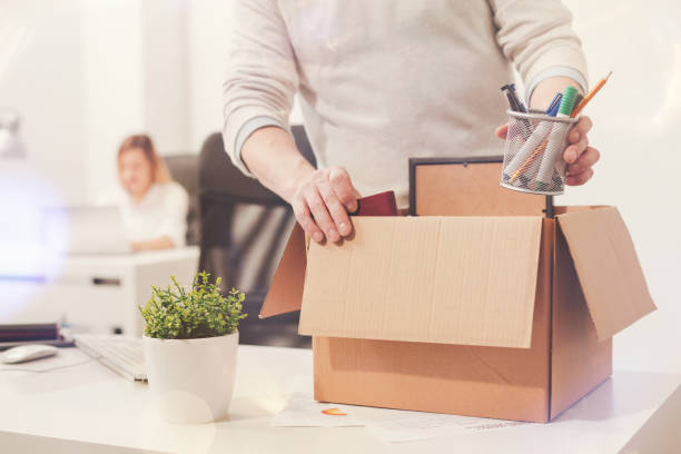 Sad dismissed worker taking his office supplies with him Nothing left behind. Attentive dedicated fired man packing his stuff in a box as he cleaning his workplace before leaving the office being fired photos stock pictures, royalty-free photos & images