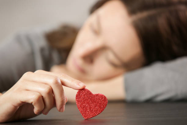 una ragazza triste tiene il cuore, l'amore e la relazione, triste concetto di san valentino - san valentino single foto e immagini stock