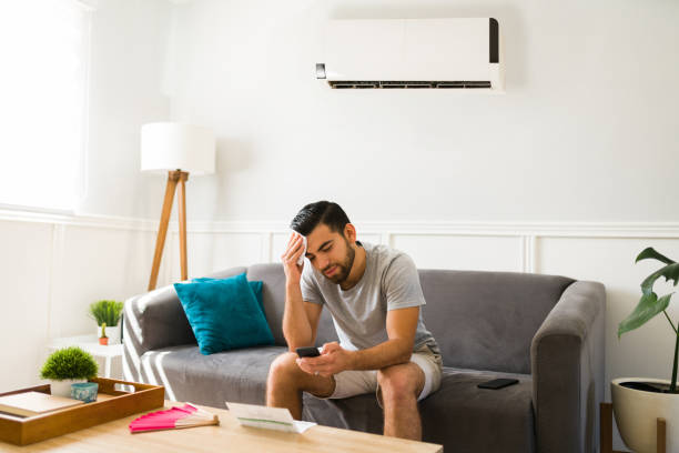 Sad man feeling hot without the air conditioner stock photo