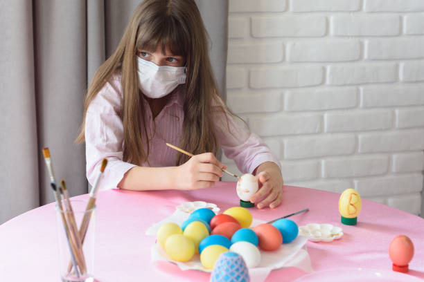 Sad sick quarantined girl paints Easter eggs  easter sunday stock pictures, royalty-free photos & images