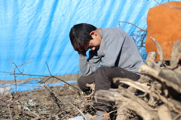 sad syrian little boy in refugee camp stock photo
