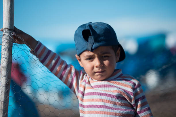 sad syrian little boy in refugee camp stock photo