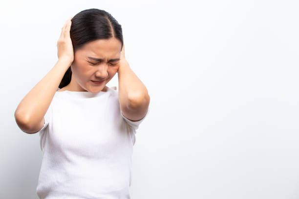 Sad woman covering her ears standing isolated over white background stock photo