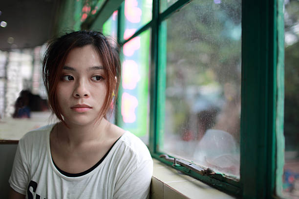Sad woman waiting someone who is late Sad woman waiting someone who is late, beside the window, in restaurant of Hong Kong brat stock pictures, royalty-free photos & images
