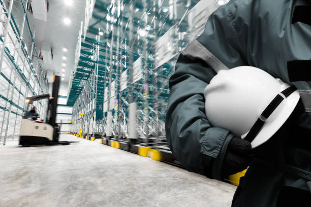 Safety hardhat for dangerous accident protection in warehouse during work. Cold room storage and freezing warehouse with stacker truck inside moving. stock photo