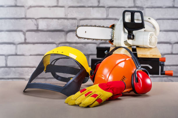 Safety protective equipment and electric saw on the workplace. Personal protective equipment for lamberjack. stock photo