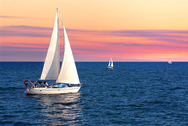 sailboats at sunset - segelbåt bildbanksfoton och bilder