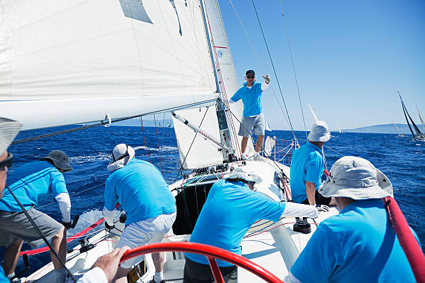 Sailing crew on sailboat stock photo