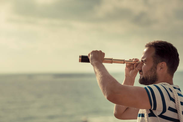 Sailor man looking through the binoculars stock photo