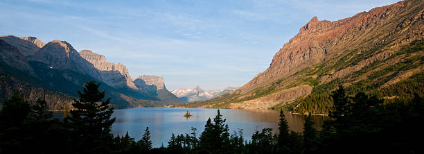 Saint Mary Lake and Wild Goose Island Saint Mary Lake, on the east side of the Continental Divide, is the second largest lake in Glacier National Park. This lake marks a meeting point between the Rocky Mountains and the Great Plains, providing some great mountain vistas from its shores. Abruptly rising from the west end of the lake are Little Chief, Gunsight and Fusillade Mountains. In the middle of the lake is tiny Wild Goose Island providing an iconic view that was featured in the opening credits of the movie “The Shining”. This scene of Saint Mary Lake and Wild Goose Island was photographed from the Wild Goose Island Overlook on the Going to the Sun Road near Babb, Montana, USA. jeff goulden montana stock pictures, royalty-free photos & images