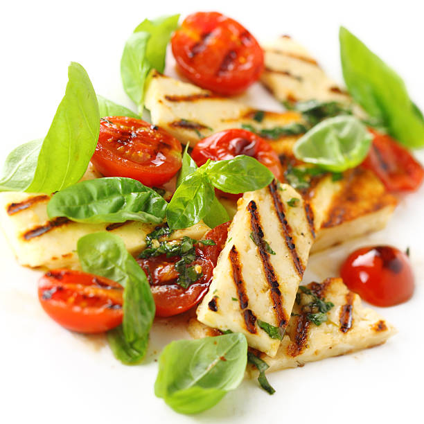 Salad with grilled halloumi cheese and roasted tomatoes stock photo