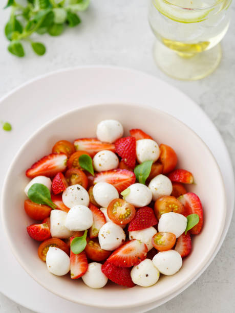 Salad with mozzarella, strawberries and cherry tomatoes. Healthy eating Vegetarian salad stock photo