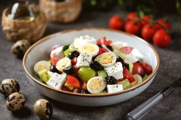 salad with quail eggs. Salad with peppers, tomatoes, cucumbers, feta, oregano, olives, onions, olive oil and lemon juice. stock photo