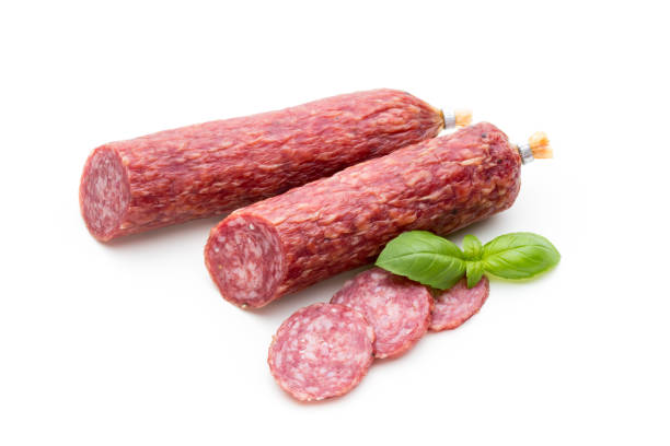 Salami smoked sausage, basil leaves and peppercorns isolated on white background. stock photo