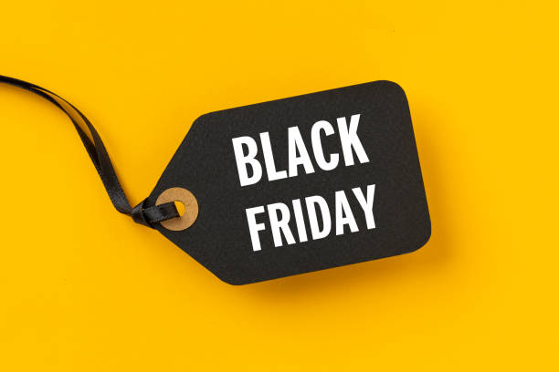 etiqueta de venta con black friday escrita sobre fondo amarillo - black friday shoppers fotografías e imágenes de stock