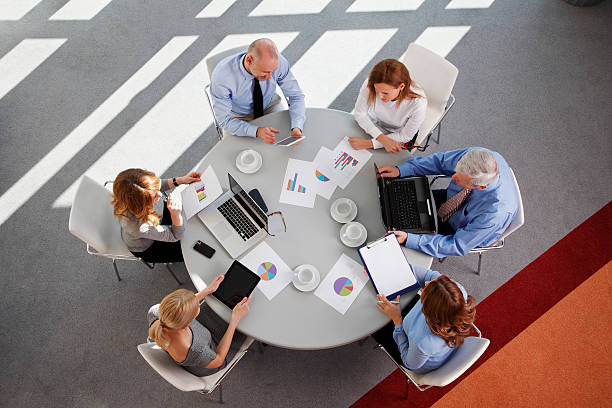 a sales team checking some graphs on a round table - retirement overview bildbanksfoton och bilder