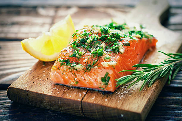 Salmon Fillet Raw salmon on a cutting board with fresh spices parsley photos stock pictures, royalty-free photos & images