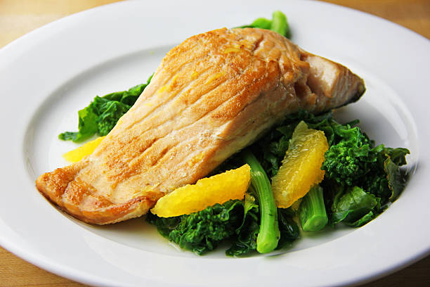 Salmon A prepared salmon dish with sweet oranges and broccoli rabe broccoli rabe stock pictures, royalty-free photos & images