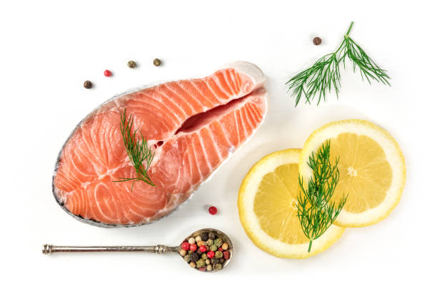 Salmon steak with lemons, dill, and peppercorns, on white An overhead photo of a raw salmon steak with dill, lemons, and peppercorns, shot from above on a white background with a place for text dill stock pictures, royalty-free photos & images