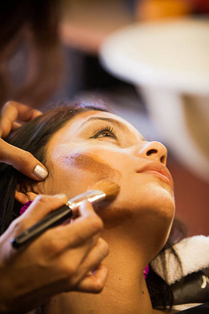 Salon Beautician Applies Makeup to a Customer stock photo