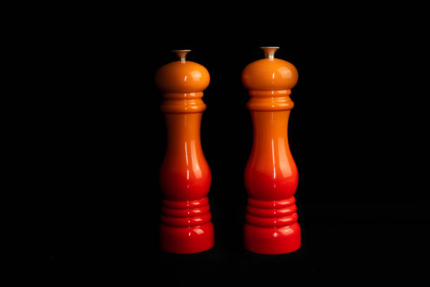 Salt and pepper mills or grinders on a black background. stock photo