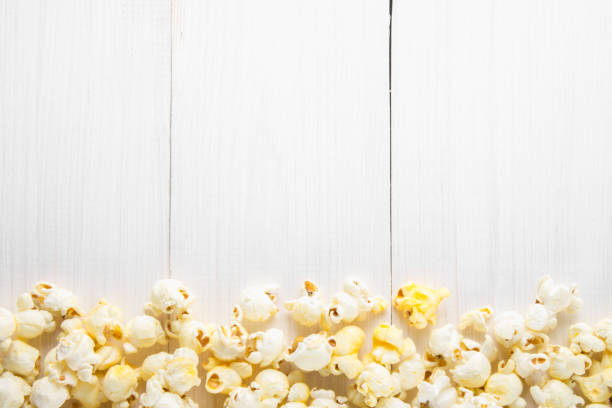 Salted popcorn on a white table. Top view. Empty space for text. stock photo
