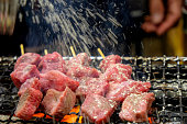 Close up male hands seasoning salt into wagyu skewer steak