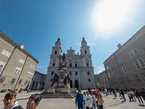 Salzburg cathedral in Salzburg, Austria.  There are people outside in the square in the spring sunshine.