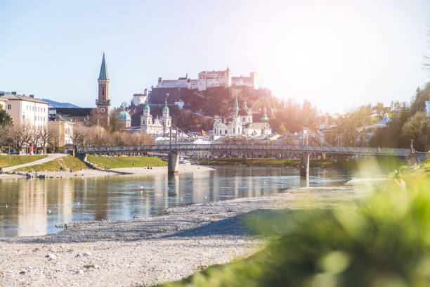 Salzburg spring time: Panoramic city landscape with Salzach with green grass and historic district stock photo